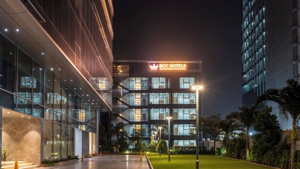 A modern hotel with a glass facade, a visible sign reading "RCC Hotels," and a well-lit entrance area. - RCC Gachibowli (Hyderabad)