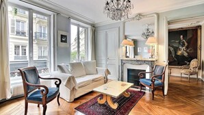 A spacious living room with a sofa, armchairs, a coffee table, and a fireplace. - Parisian Home | 2 chambres | Marais - Bastille (Paris)