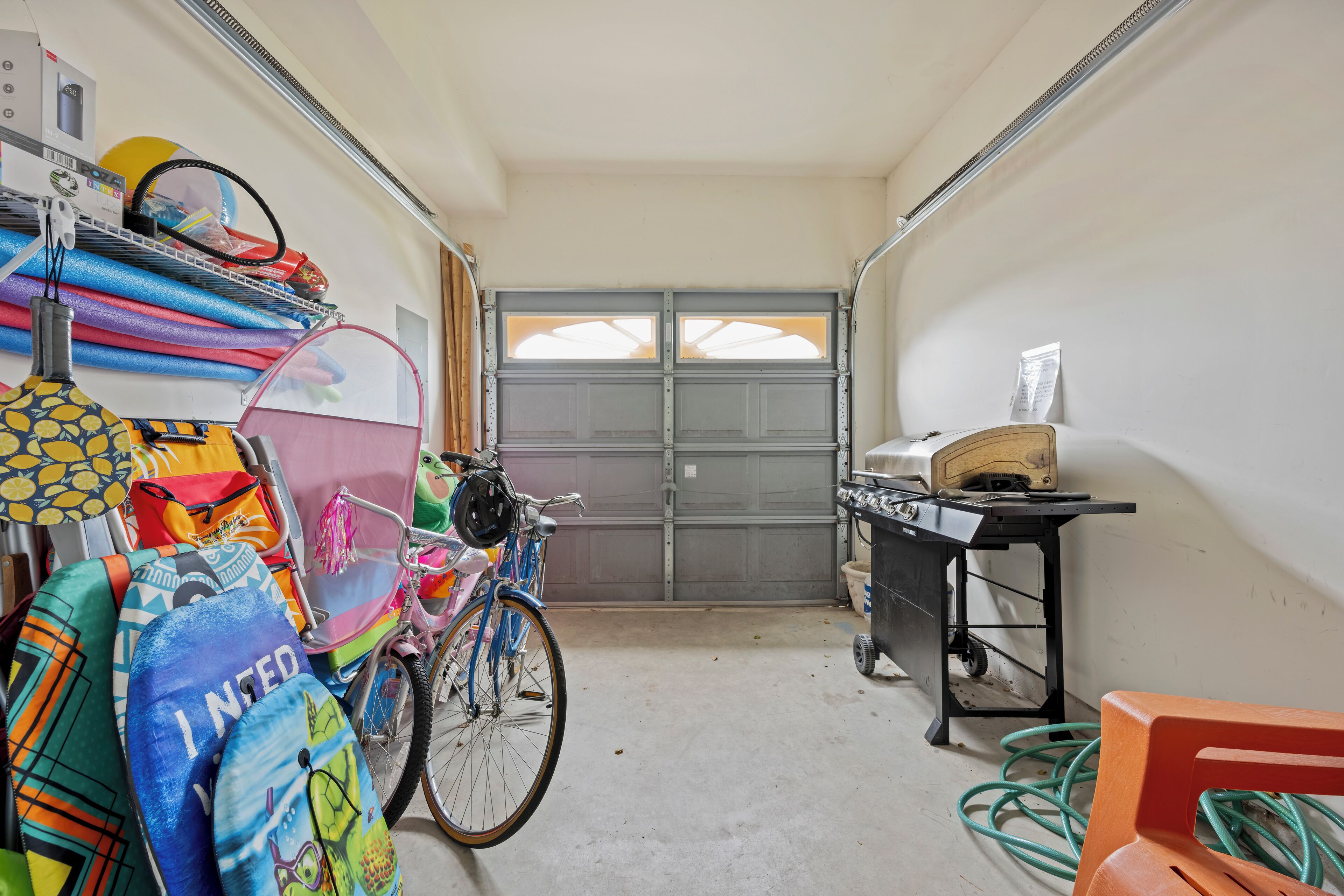 A narrow hallway with a bicycle, colorful bags, and a table with a tape measure.