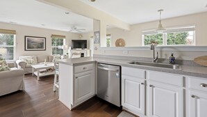 A modern kitchen with white cabinetry, a dishwasher, and a large window. - SUPER SPACIOUS TOWNHOUSE IN POOL CMMTY- 3101 The Palms, Rehoboth (Rehoboth Beach)