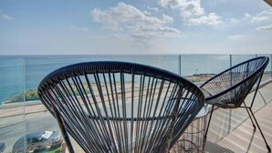 A balcony with two black wire chairs facing a coastal view. - Mediterranean Luxury Stay with Sea Views & Jacuzzi (Xgħajra)