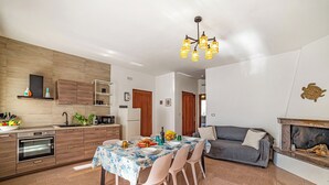 Uma cozinha moderna com área de refeições, um sofá e uma lareira.