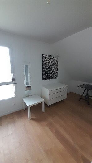 A room with a white bench, a white dresser, a black and white artwork on the wall, and a window. - New house - 6 people - 3 bedrooms (Saint-Gildas-de-Rhuys)