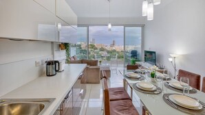 Una cocina moderna con comedor, ventanas amplias y vista a la ciudad.