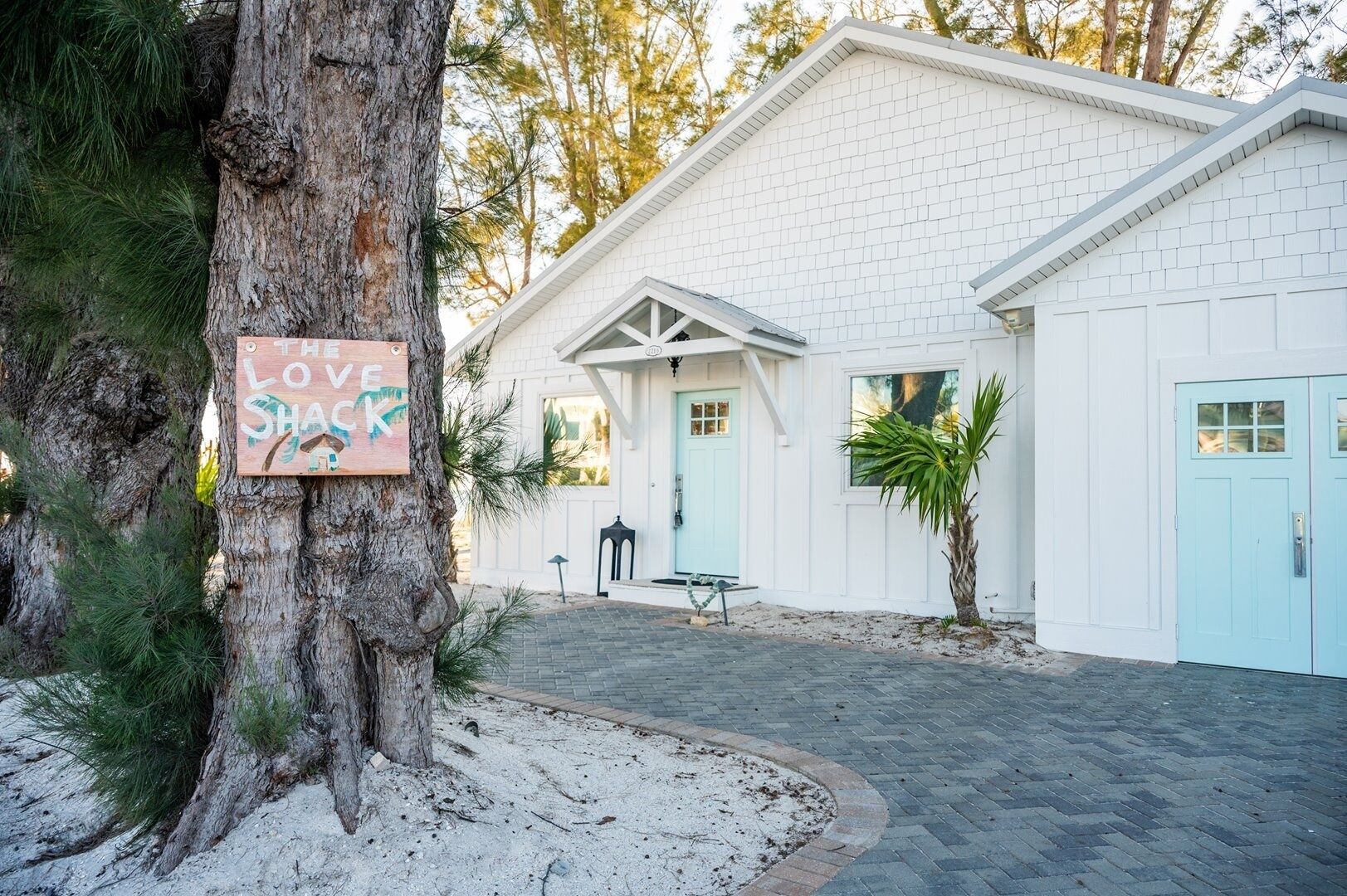 A white building with a blue door and a sign that reads "The Love Shack."