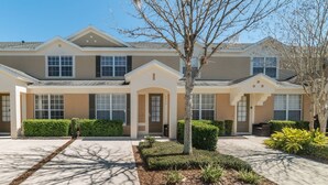 A two-story residential building with a symmetrical facade, multiple windows, and a central entrance with a small porch. - Windsor Hills 3 Bedroom Private Pool Townhome 3 Townhouse (Kissimmee)