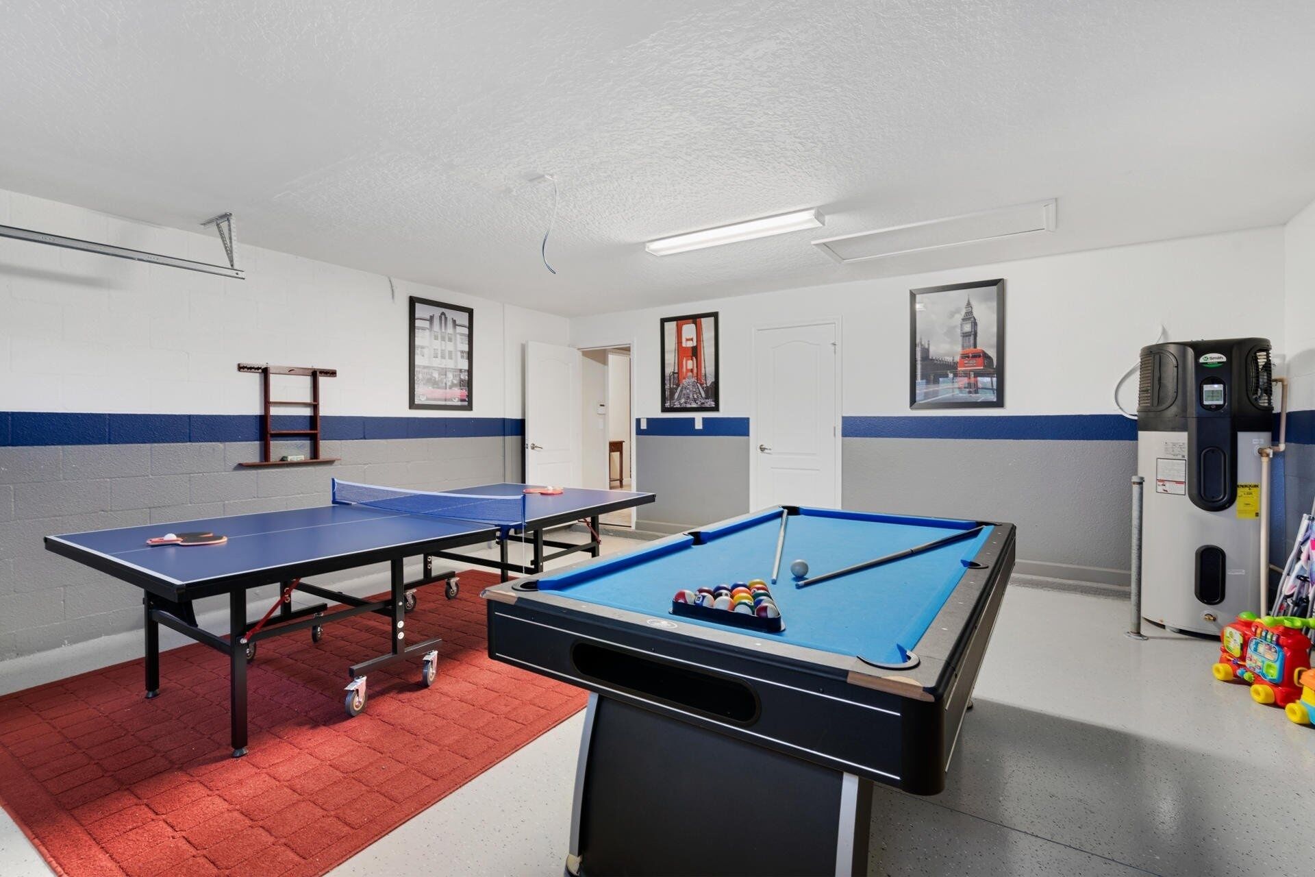Una habitación con mesa de ping pong, mesa de billar y refrigerador.