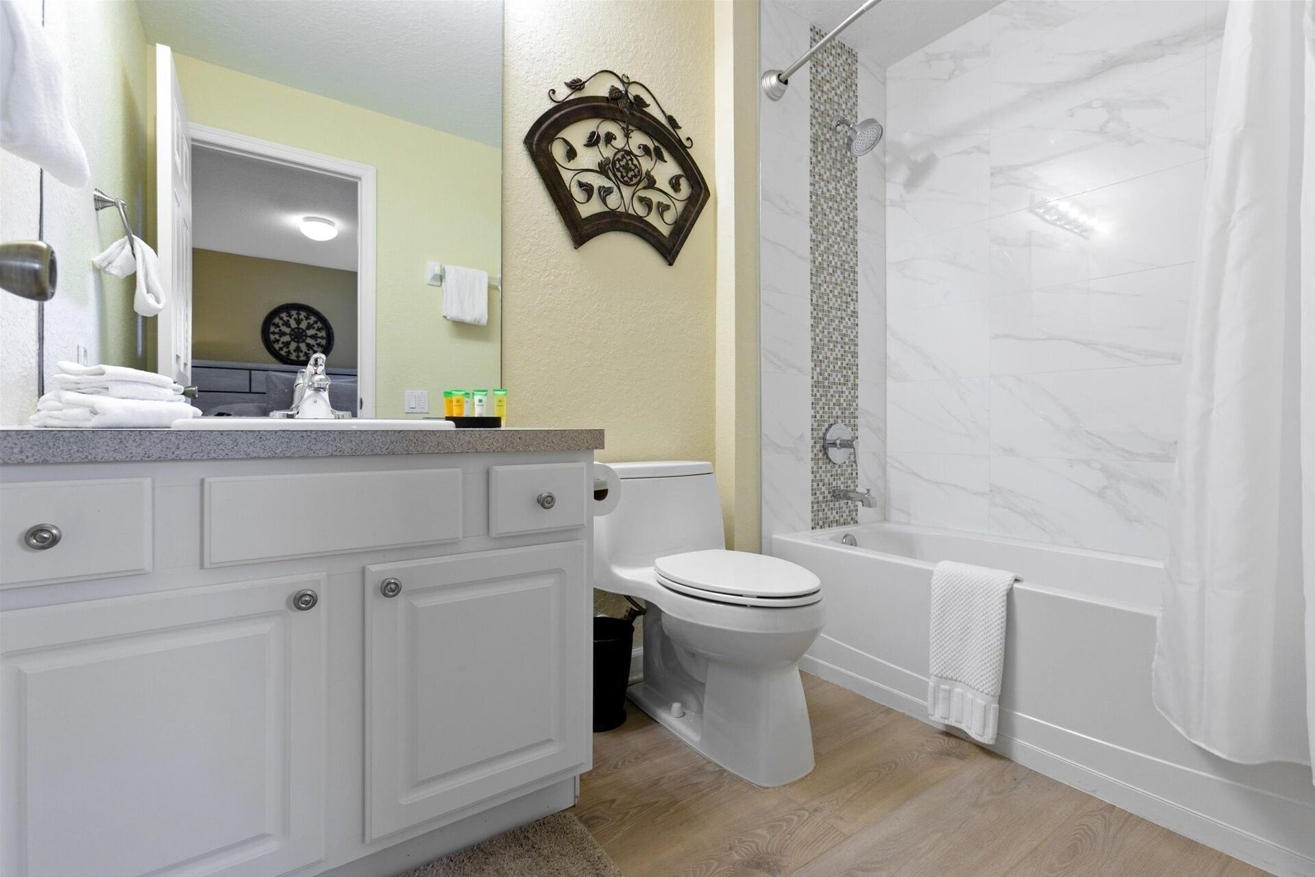 A bathroom with a white vanity, toilet, and shower area.
