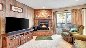 A living room with a fireplace, a television, and a cozy seating area. - Chamonix 33: Close to Canyon Lodge (Mammoth Lakes)