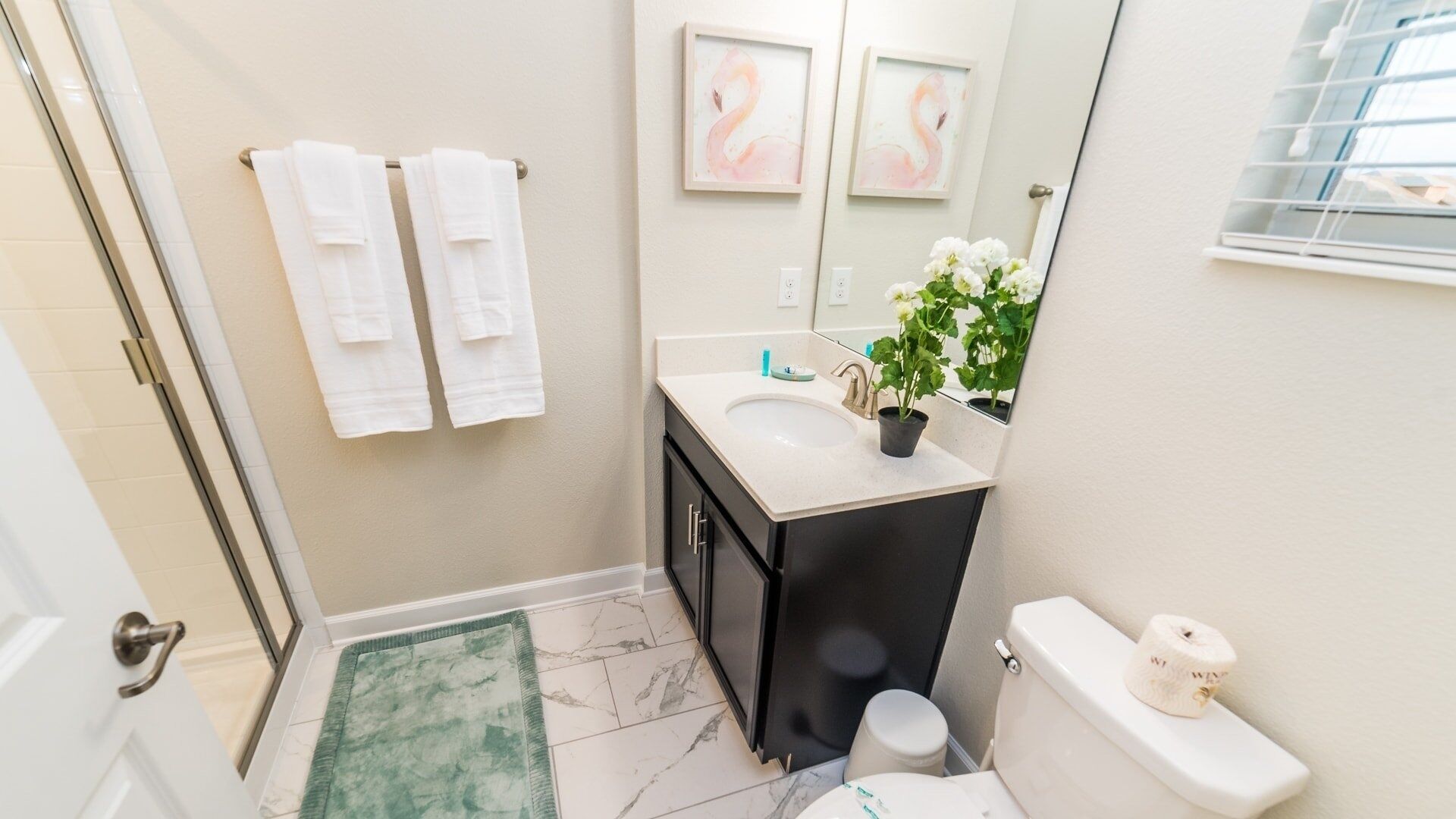 Une salle de bain avec un lavabo blanc, des toilettes et un espace douche.