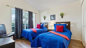 A room with two beds, a chair, a desk, and a window with curtains. - 4 Bedroom Private Pool+Spa Home 8 Miles to Disney 4 Home (Kissimmee)
