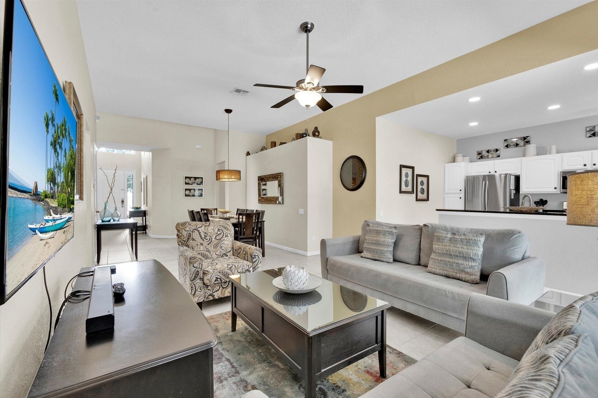 A modern living room with a sofa, coffee table, and a dining area with chairs.
