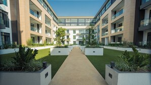 En modern byggnad med en central innergård, omgiven av balkonger och stora fönster.