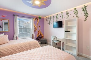 Ein Schlafzimmer mit zwei Betten, einem Schreibtisch, einem Fernseher und einem Bücherregal.