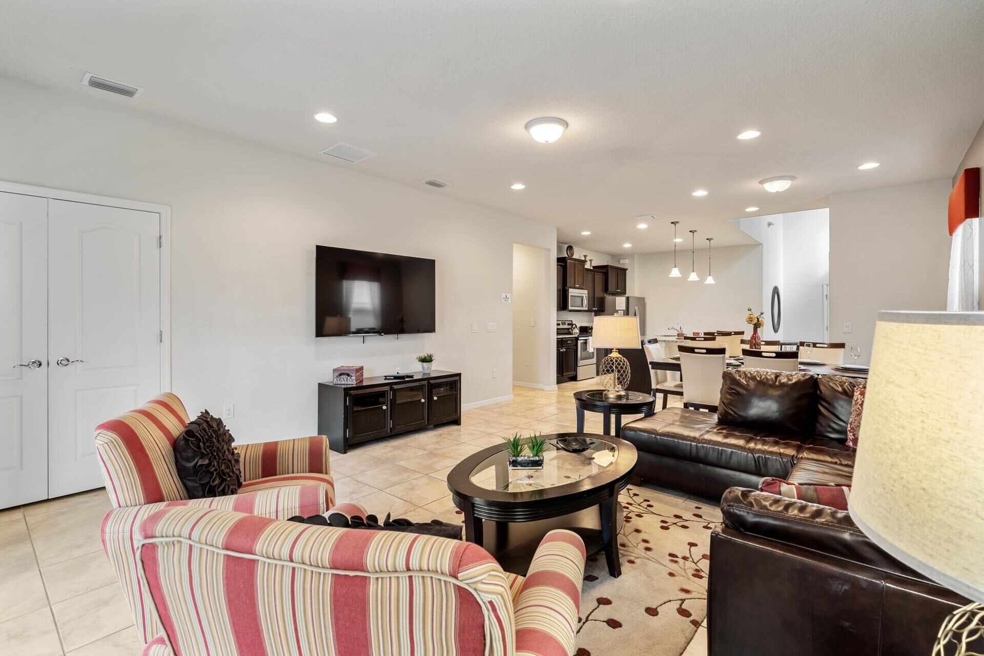A modern living room with a sofa, armchairs, a coffee table, and a TV.