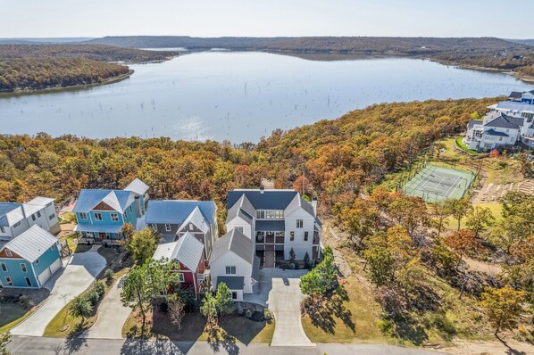 A residential area with houses, a tennis court, and a lake. - Carlton Landing-Redeemed Waters (Carlton Landing)