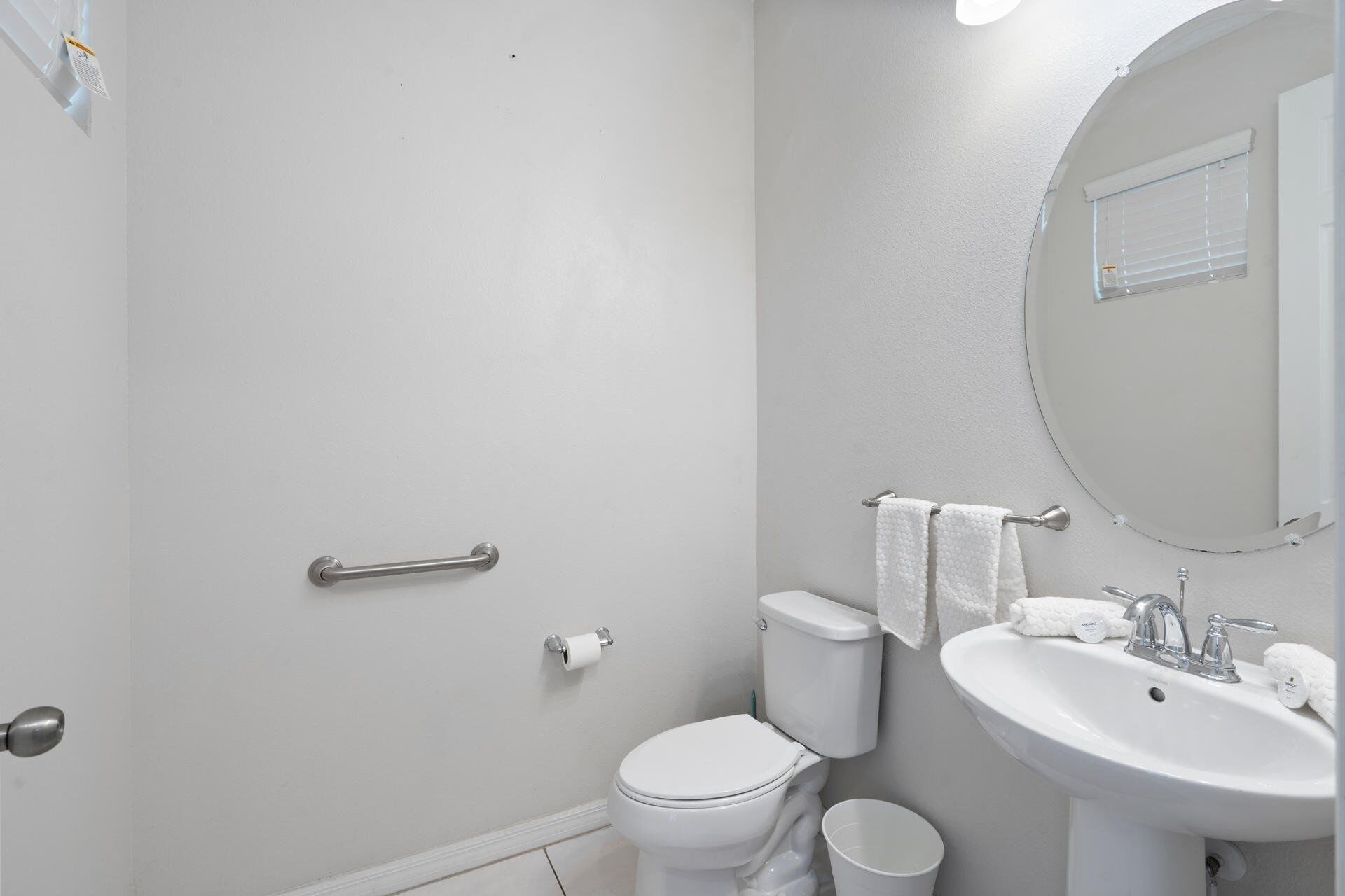 A bathroom with a toilet, sink, and mirror.