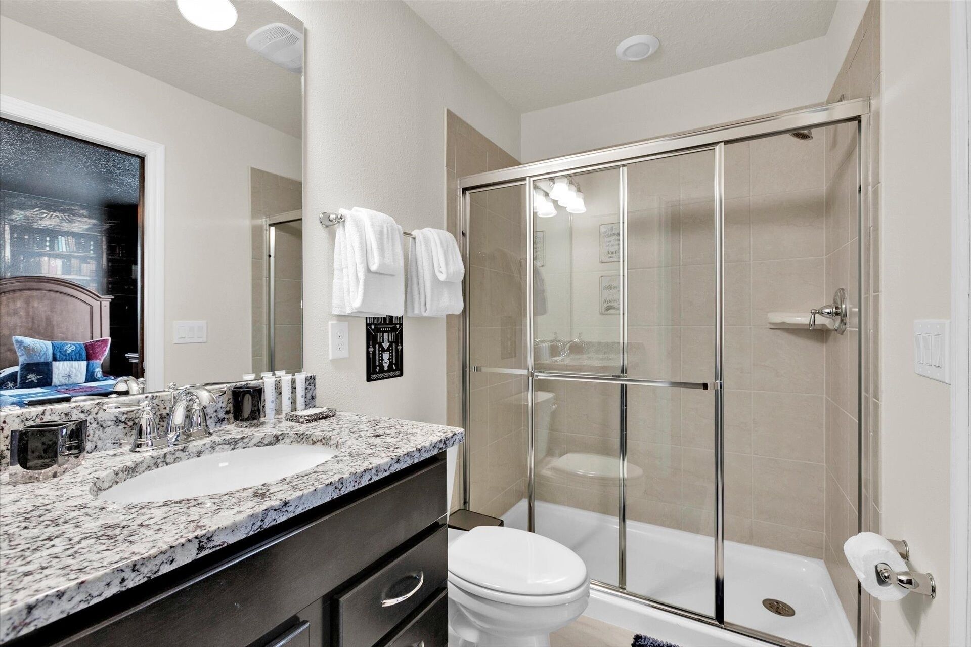 Une salle de bain moderne avec une douche à parois de verre, un meuble-lavabo à deux vasques et des toilettes.