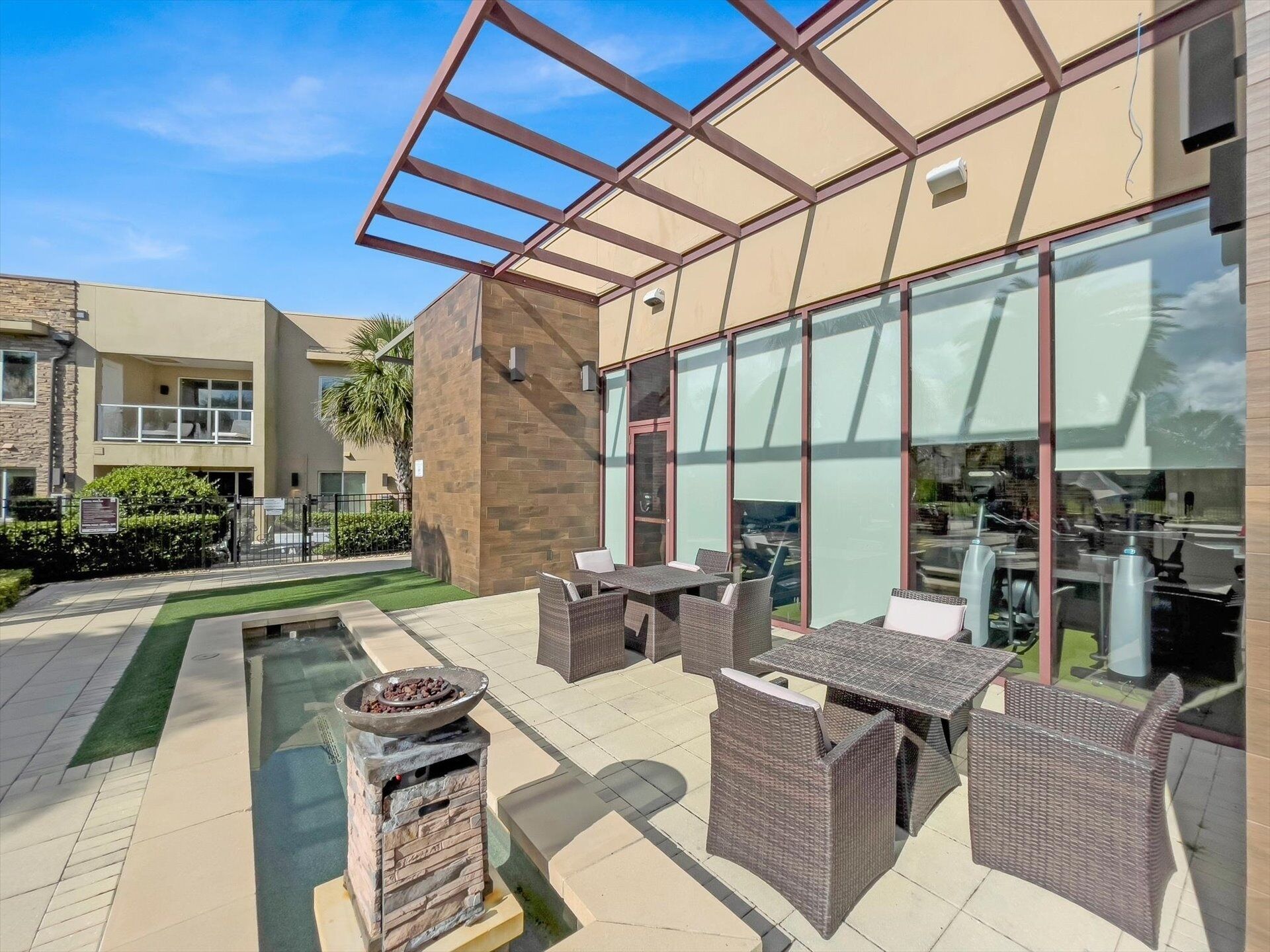 Un espace extérieur moderne, aménagé en patio, avec des meubles d’extérieur et un foyer.