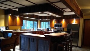 A spacious kitchen with wooden cabinets, a large island, and a built-in microwave.