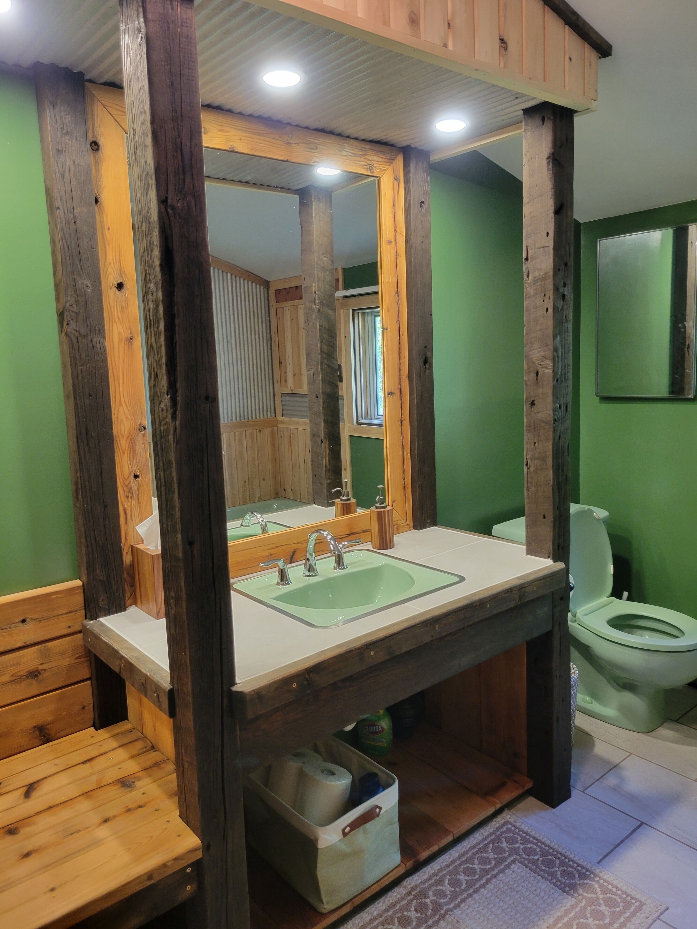A bathroom with a wooden vanity, a sink, and a toilet.