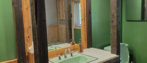 A bathroom with a wooden vanity, a sink, and a toilet.