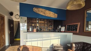 A modern bar area with a world map on the wall, leather seating, and a staircase leading to a lower level. - LA VILLA JULIA (Agon-Coutainville)