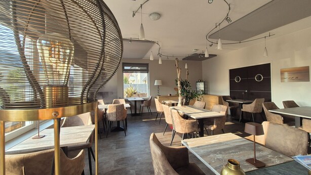 A modern dining area with round tables and cushioned chairs, a large woven light fixture, and a view of the outside. - LA VILLA JULIA (Agon-Coutainville)