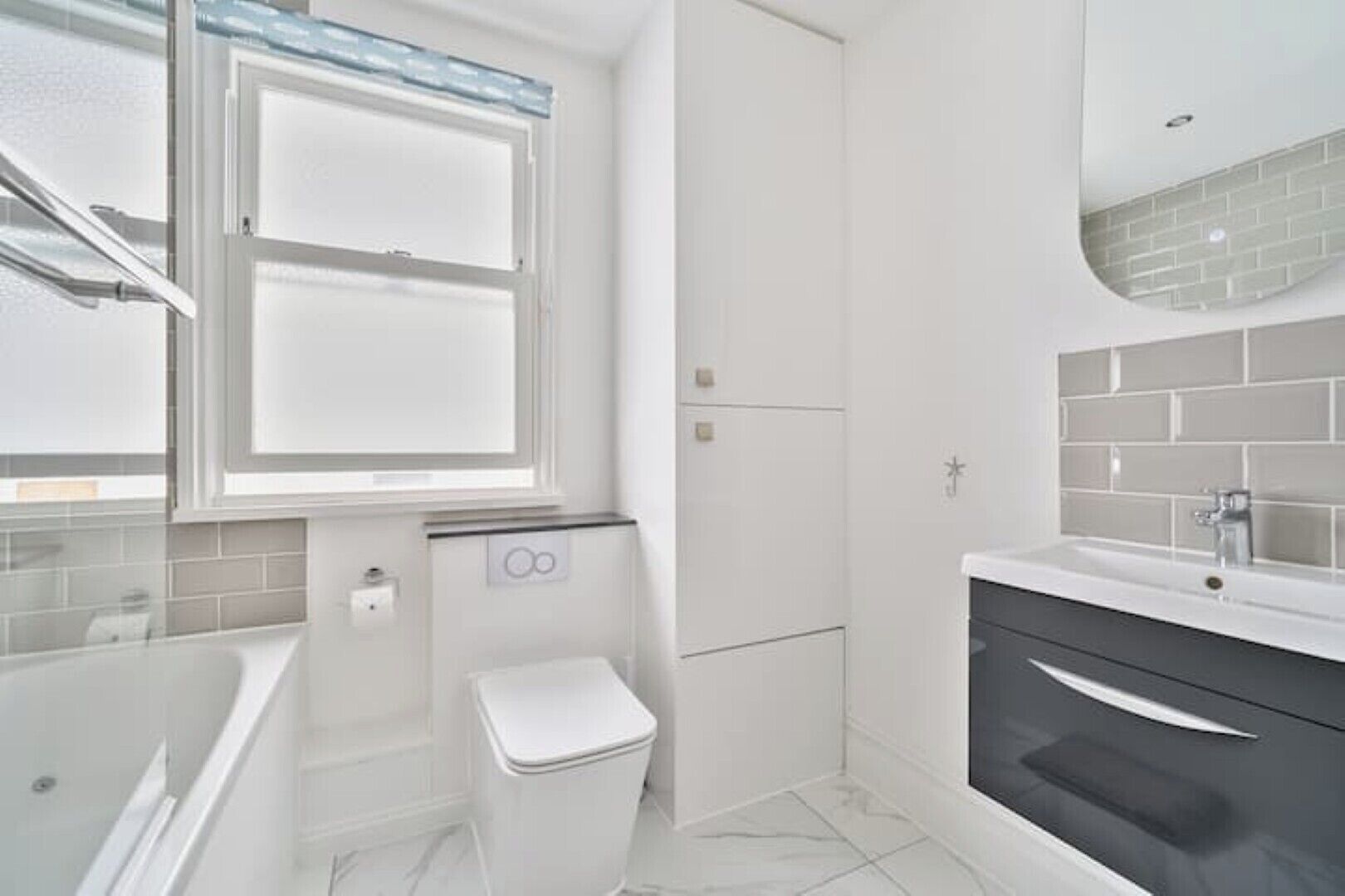 A modern bathroom with a bathtub, toilet, and sink.