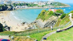 A coastal town with a beach, rocky cliffs, and a pathway leading to a viewpoint overlooking the sea. - Beachfront Luxury Home with Hot Tub, 9 beds, Cinema room, Sleeps 2 to 16 (Newquay)