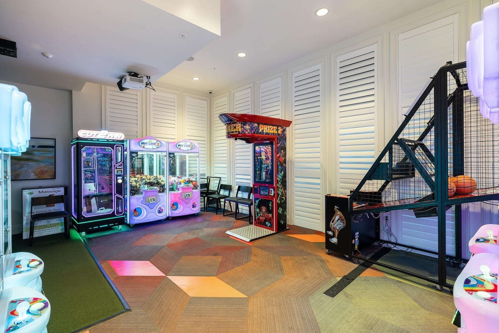 Una stanza con giochi arcade, servizio massaggi e canestro da basket.