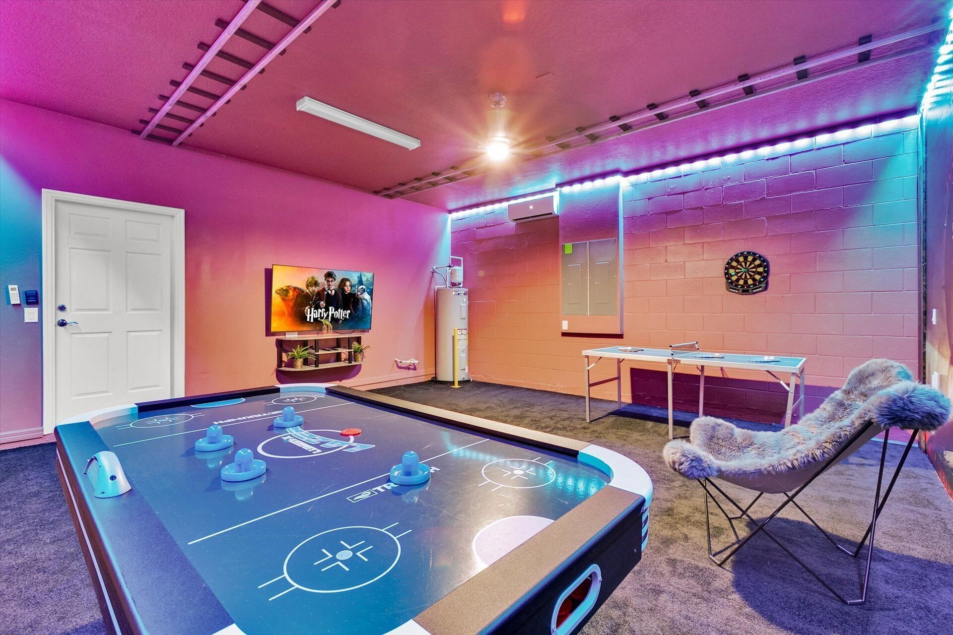 A room with a pool table, a dartboard, and a TV displaying 'Harry Potter'.
