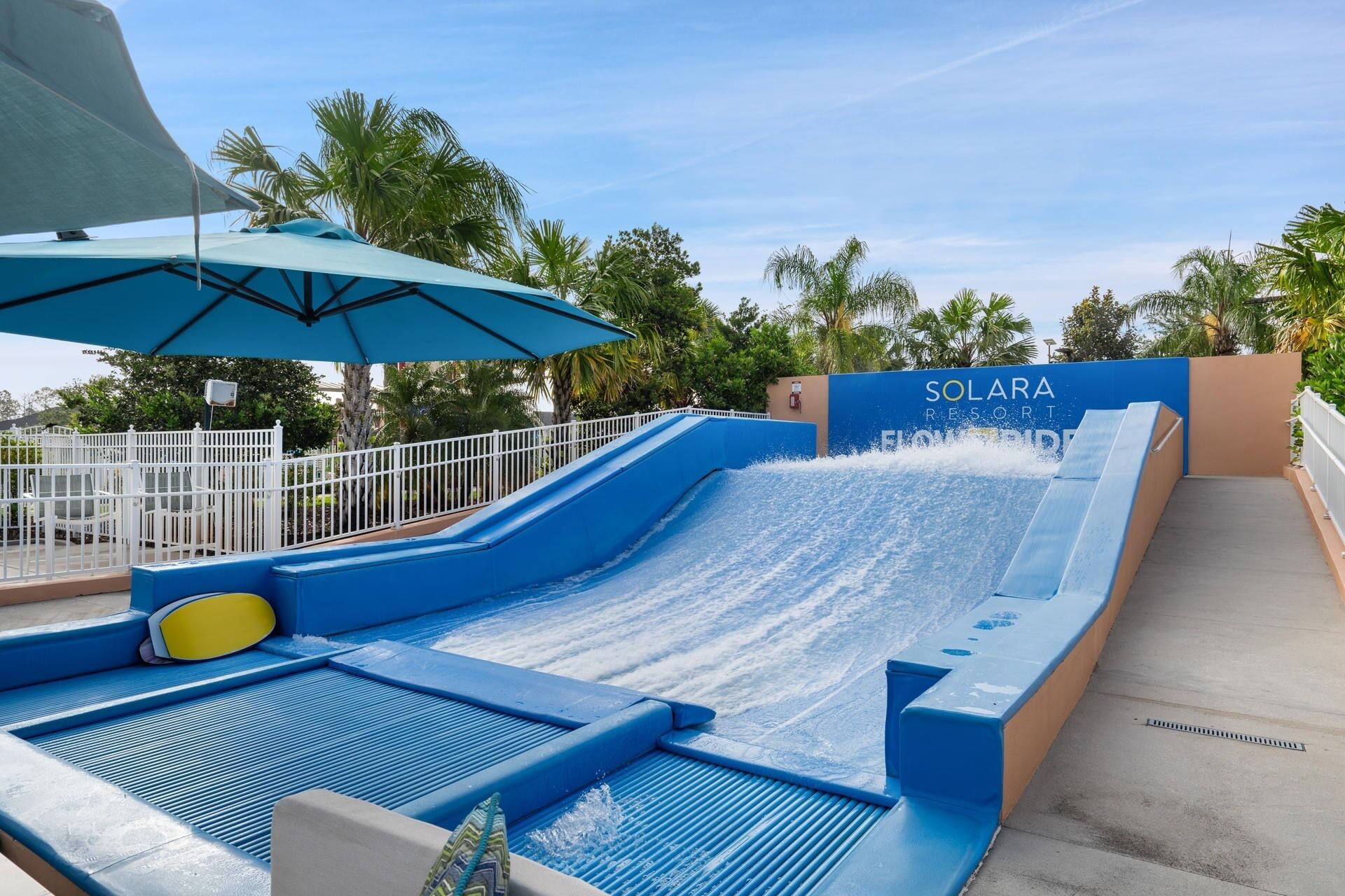 Un tobogán de agua en el Solara Resort, con un tobogán azul y una zona de piscina.