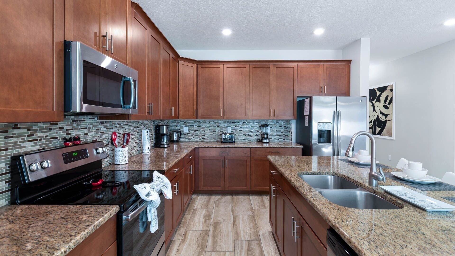 A modern kitchen with wooden cabinets, stainless steel appliances, and a granite countertop.