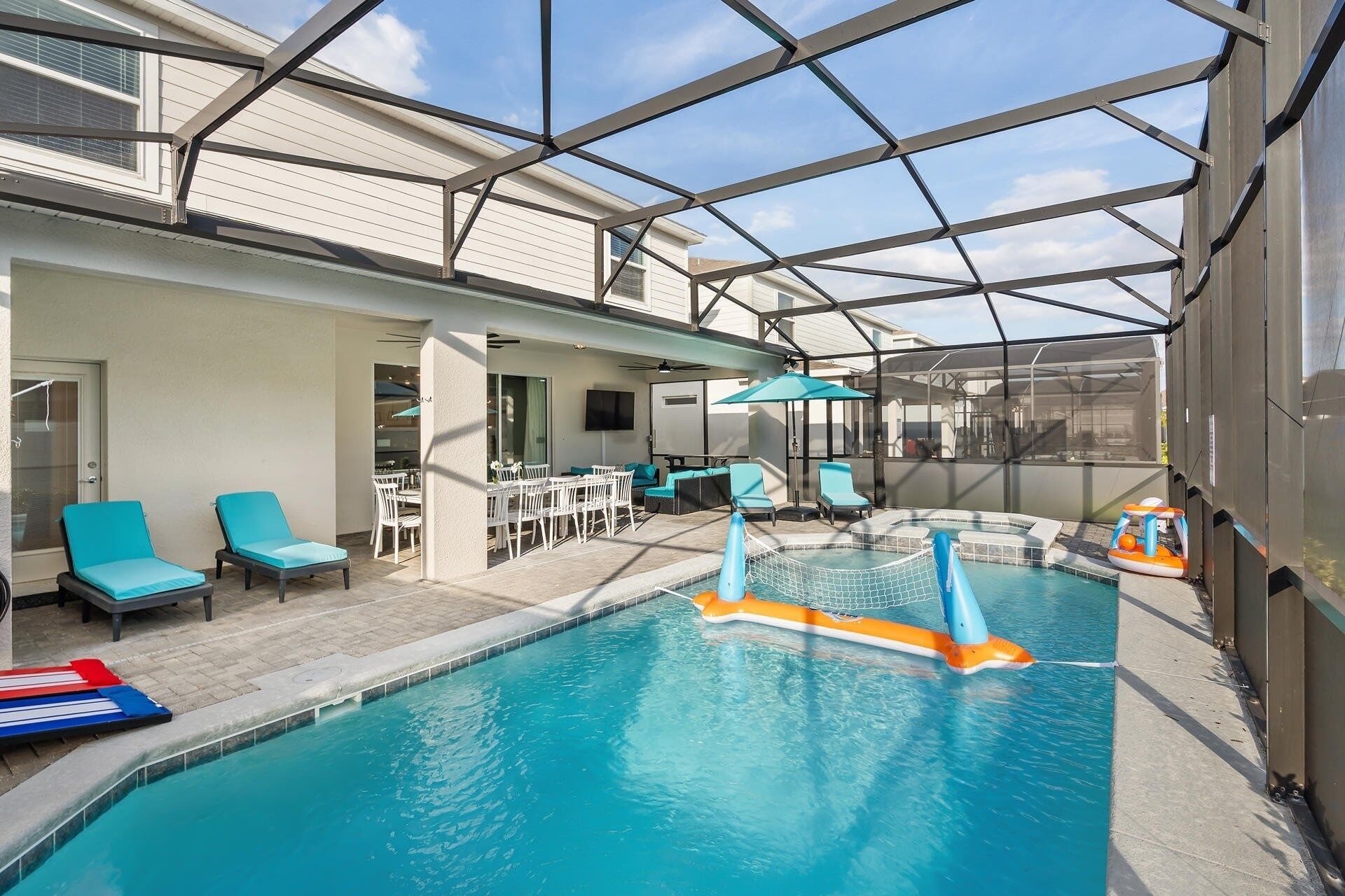 An indoor swimming pool with a glass ceiling, lounge chairs, and a slide.