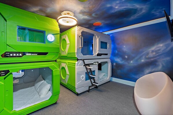 A room with two green bunk beds, a white chair, and a starry nebula mural on the ceiling. - 20 Bedroom Hollywood Themed Mansion Private Pool+Lazy River 20 Home (Davenport)