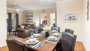 A dining room with a wooden table set for four, surrounded by leather chairs. - Tuscana Resort 2 Bedroom Condo Clubhouse Access 8 miles to Disney 2 Condo (Davenport)