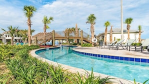 A swimming pool with lounge chairs, palm trees, and a covered area. - Storey Lake Resort 2 Bedroom Condo with Private Balcony 2 Condo (Kissimmee)