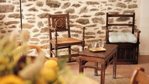 Une table à manger en bois, avec des chaises, un verre et une assiette.