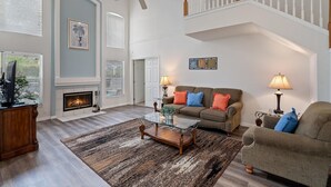 A spacious living room with a fireplace, a high ceiling, and a staircase. - Highlands Reserve 4 Bedroom Vacation Home with Private Pool 4 Hotel Room (Davenport)