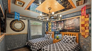 A hotel room with a large clock, two beds with patterned bedding, a chandelier, and a Harry Potter-themed wall. - Highlands Reserve 4 Bedroom Vacation Home with Private Pool 4 Hotel Room (Davenport)