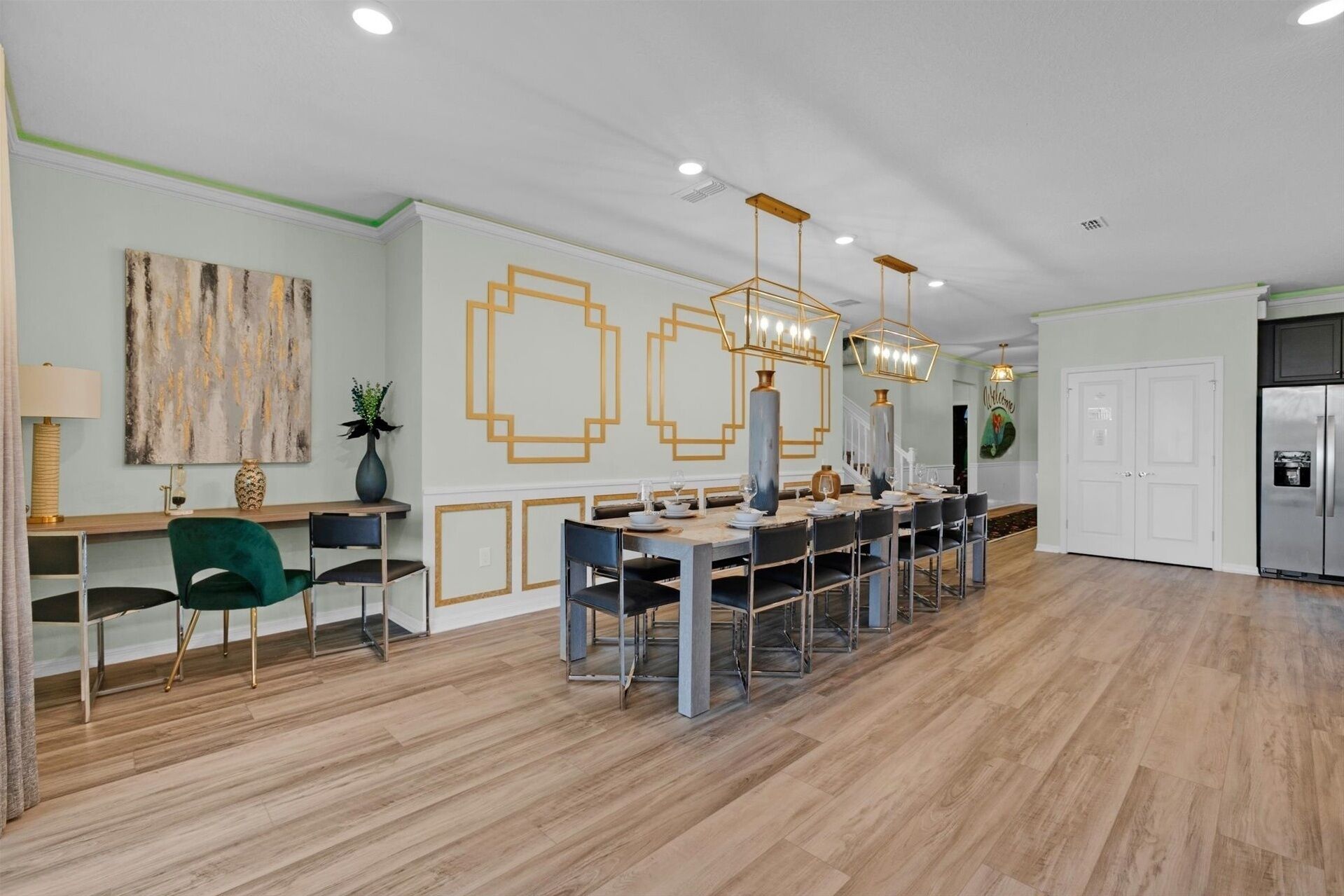 A modern dining area with a long table, chairs, and pendant lighting.