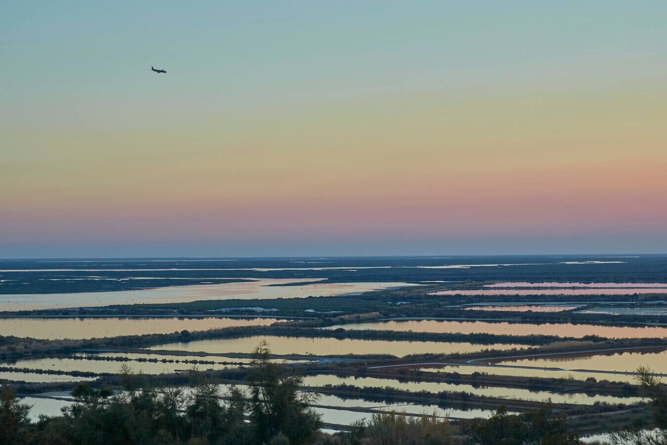 Eine Küstenlandschaft mit mehreren Wasserscheiden und einem entfernten Flugzeug.