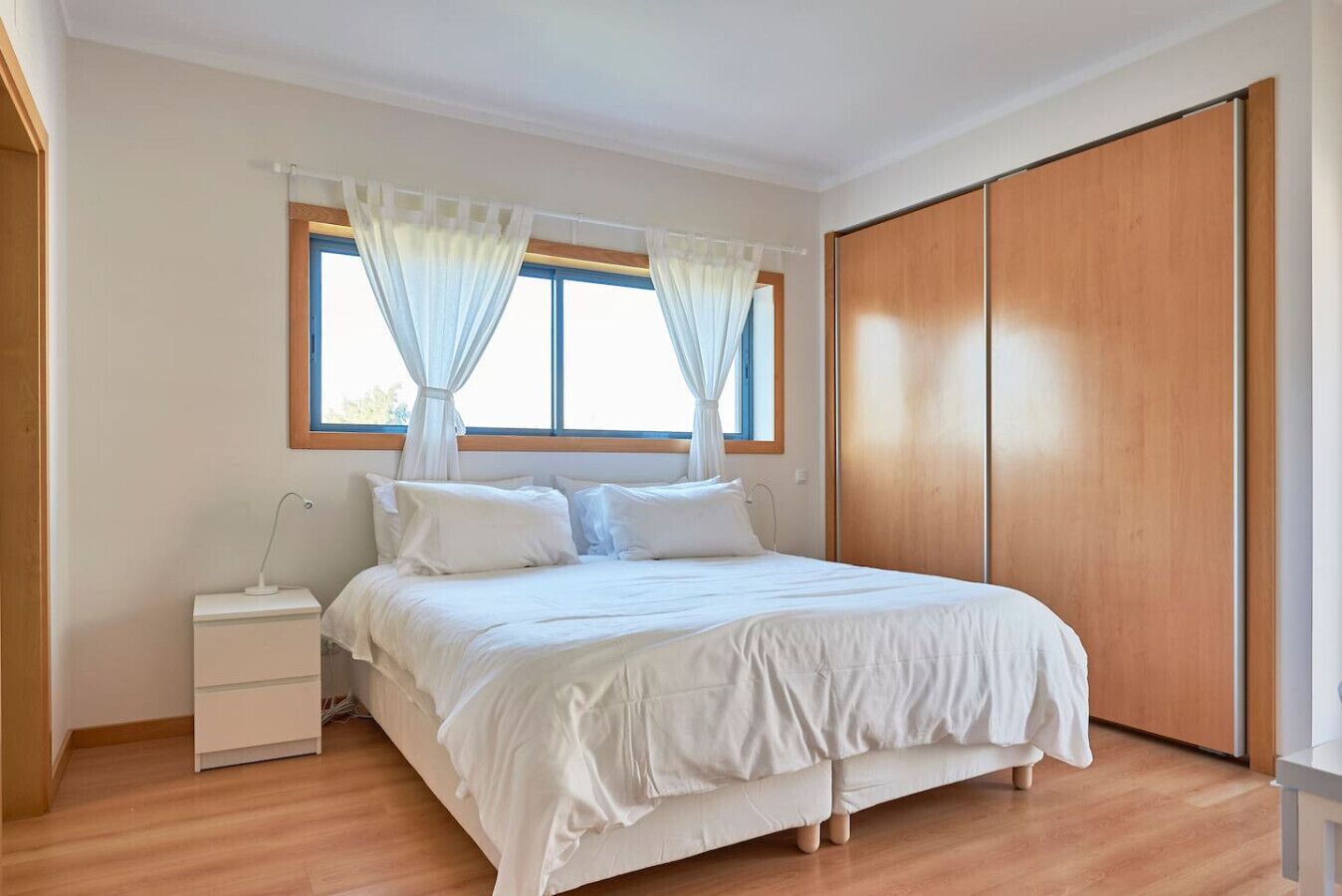 Une chambre à coucher avec un lit, une table de chevet et une armoire.