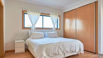Une chambre à coucher avec un lit, une table de chevet et une armoire.