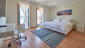 Un dormitorio moderno con una cama, un escritorio y una silla.