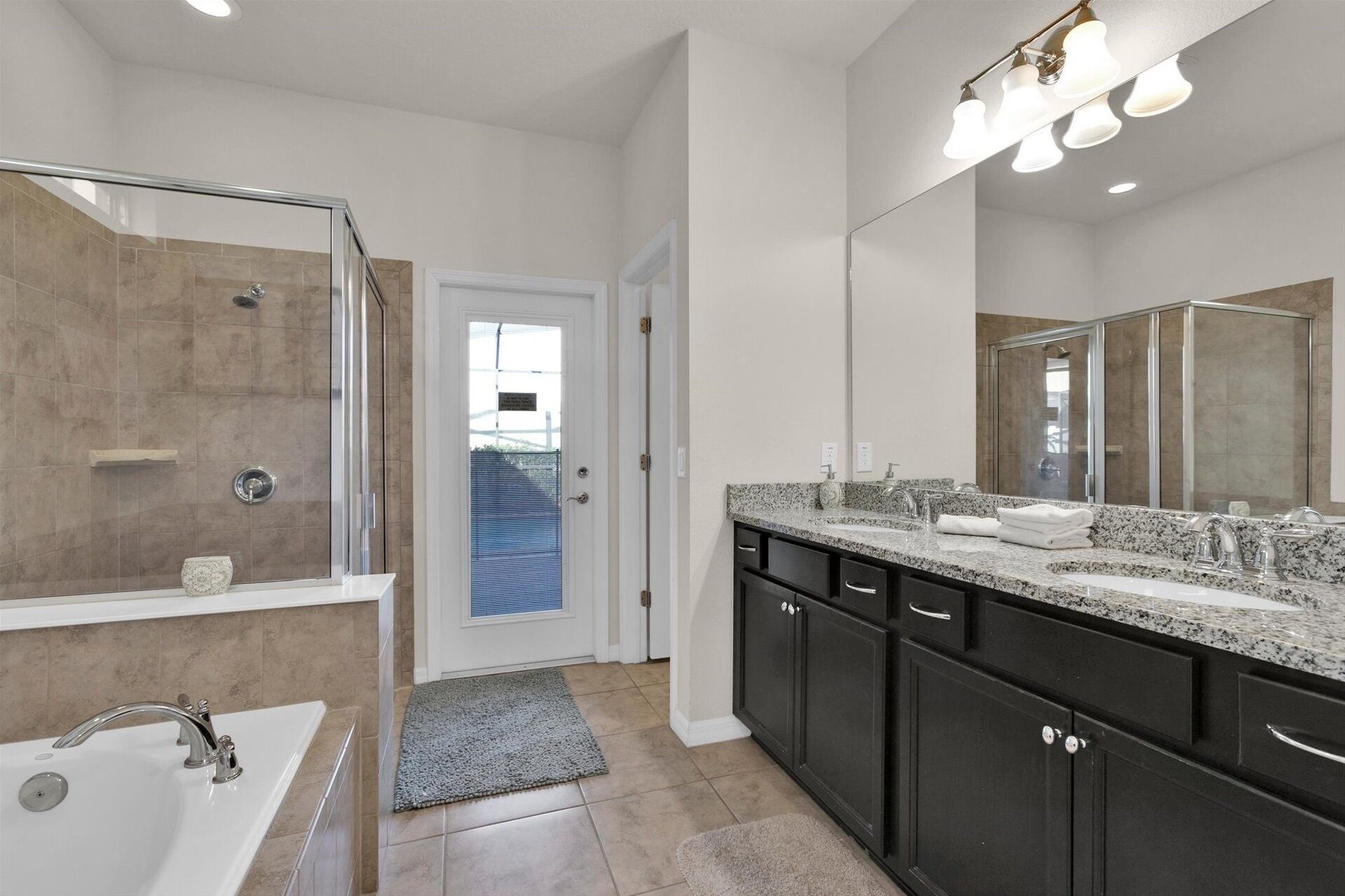 A modern bathroom with a shower, sink, and vanity.