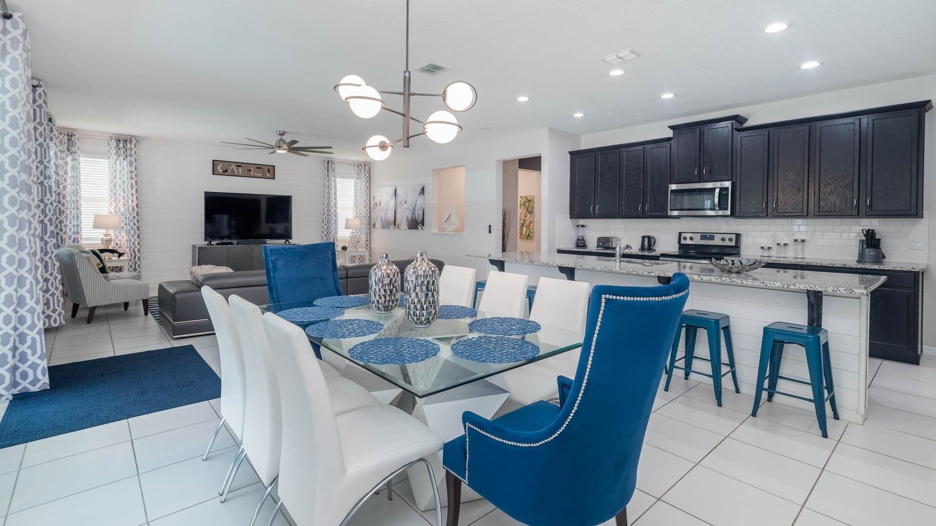 A modern kitchen with dark cabinets, a microwave, and a stove.