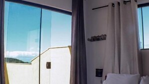 Una habitación de hotel con una cama grande, vistas al exterior y un balcón.