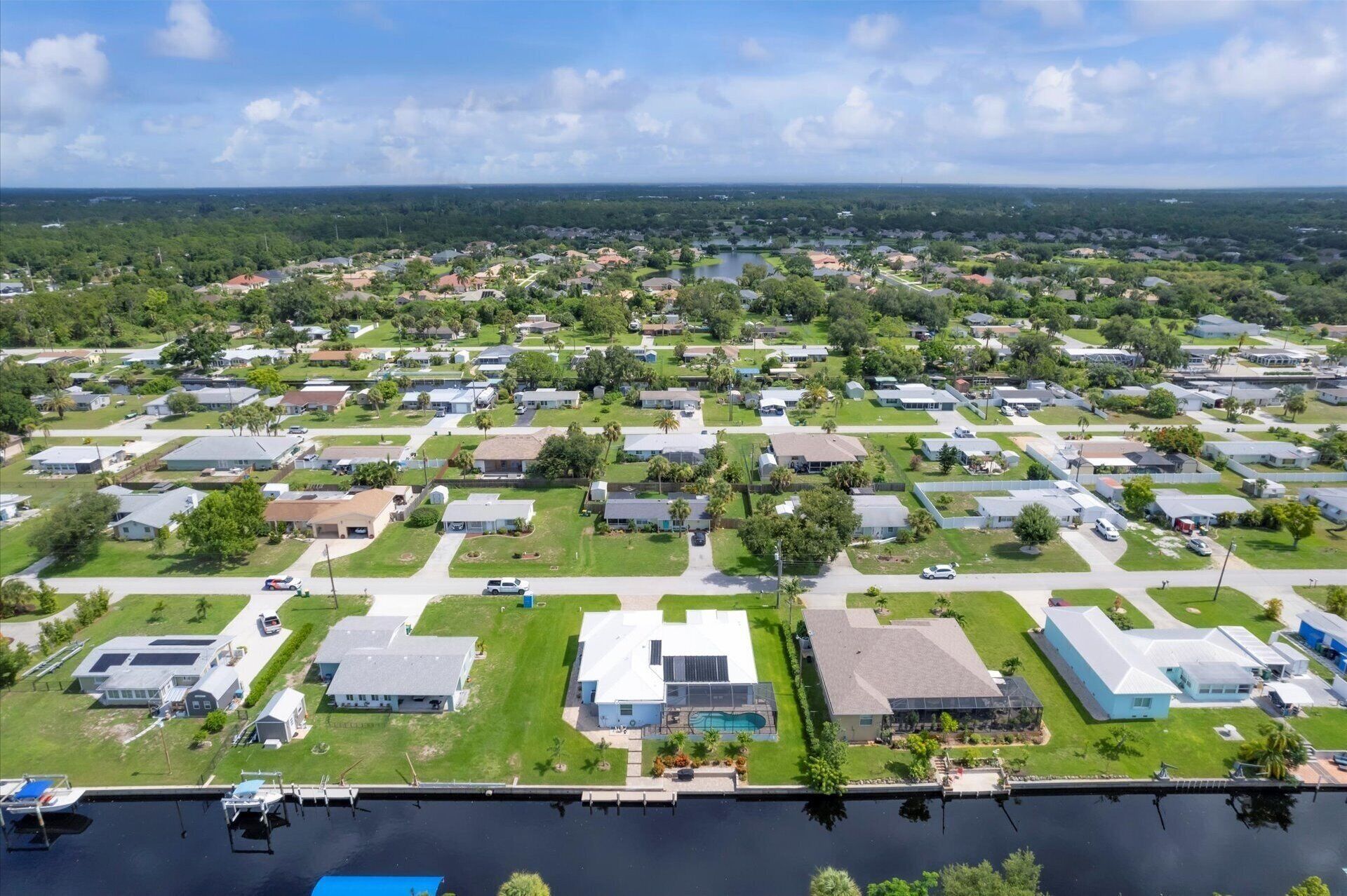 Luchtbeeld van een woongebied met huizen, een jachthaven en een groot wateroppervlak.